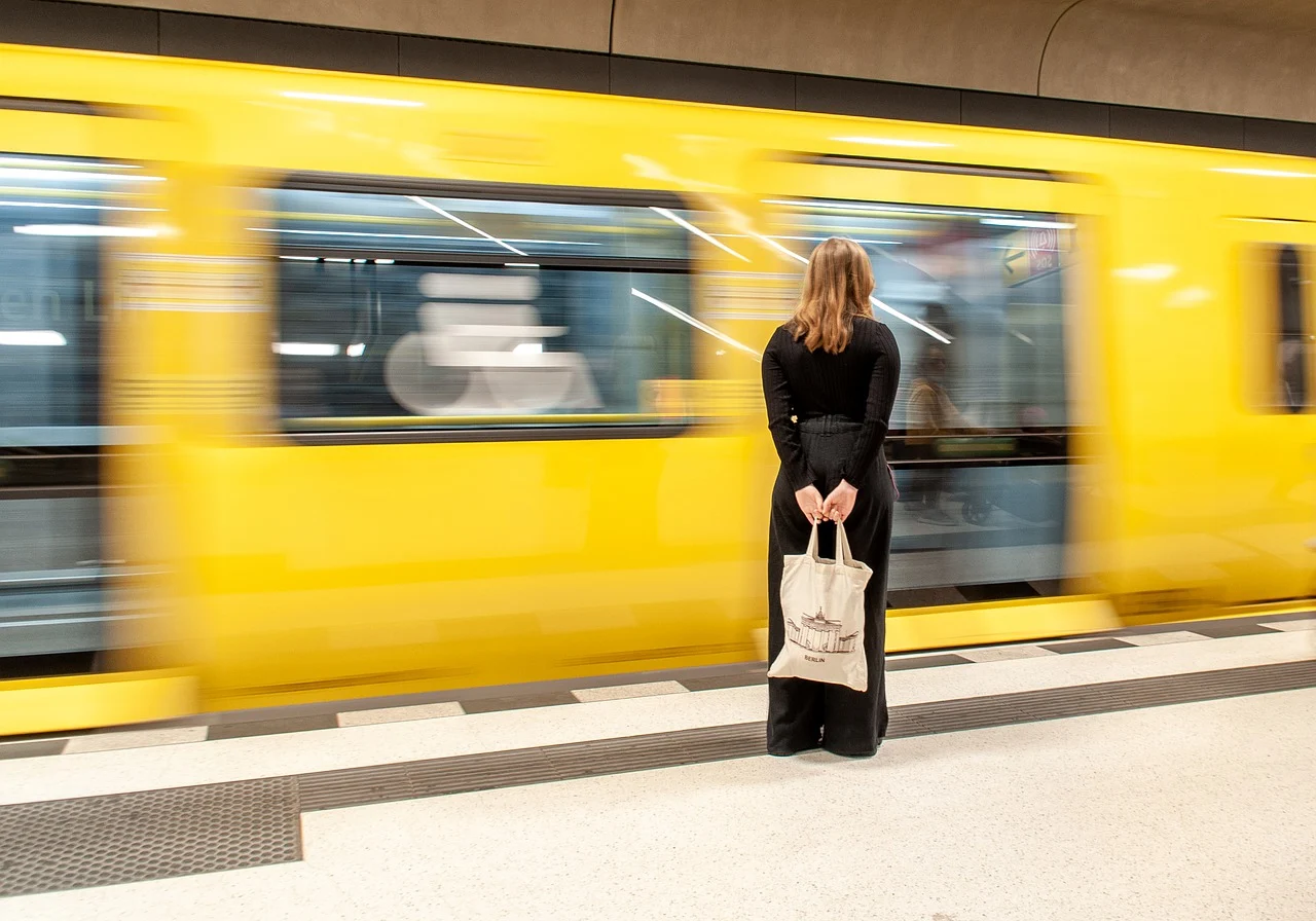 Une femme attend le métro sur le quai.
