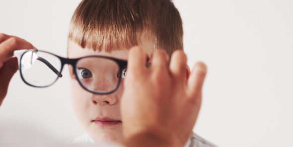 Image d'un enfant à qui l'on met des lunettes de vue